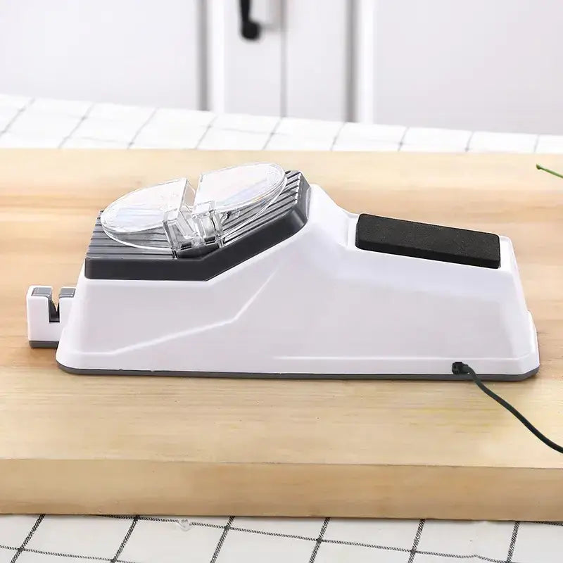 White and black electric knife sharpener with a clear plastic cover over the sharpening stones.
