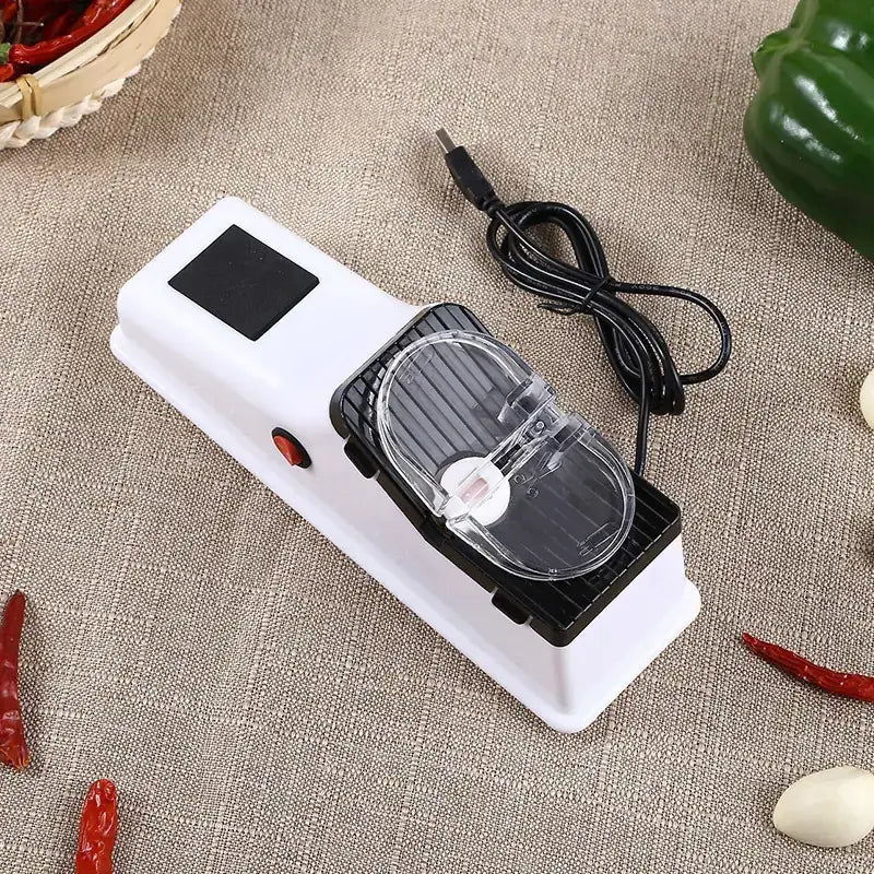 White and black electric knife sharpener with a clear plastic cover over the sharpening mechanism.