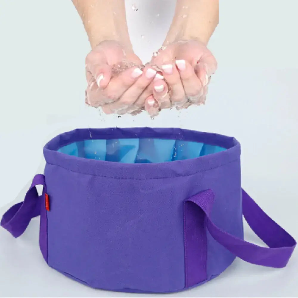 Purple collapsible camping shower basin with blue interior lining and fabric handles.