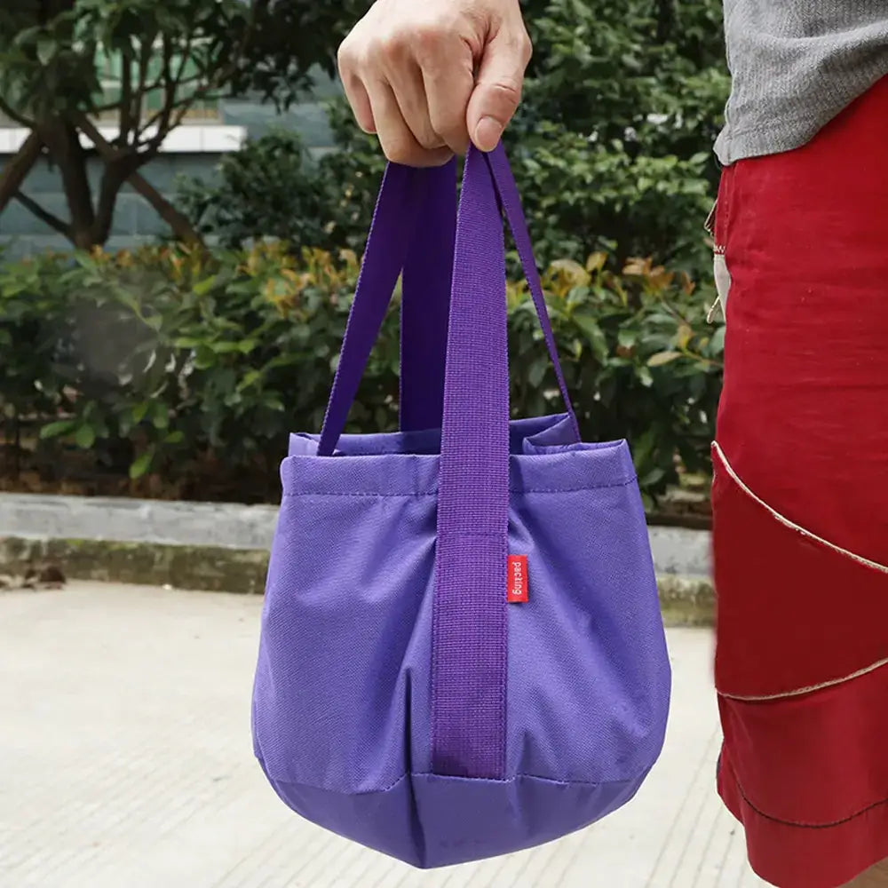 Purple fabric tote bag with matching handles and a small red brand tag.