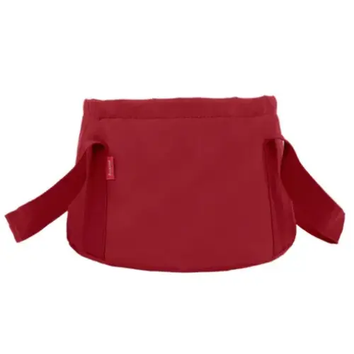 Red fabric baby carrier with adjustable straps and a small brand tag on the side.
