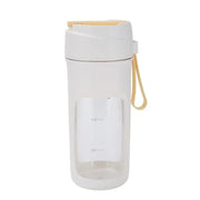 White and beige travel blender with a clear body, white lid, and carrying strap