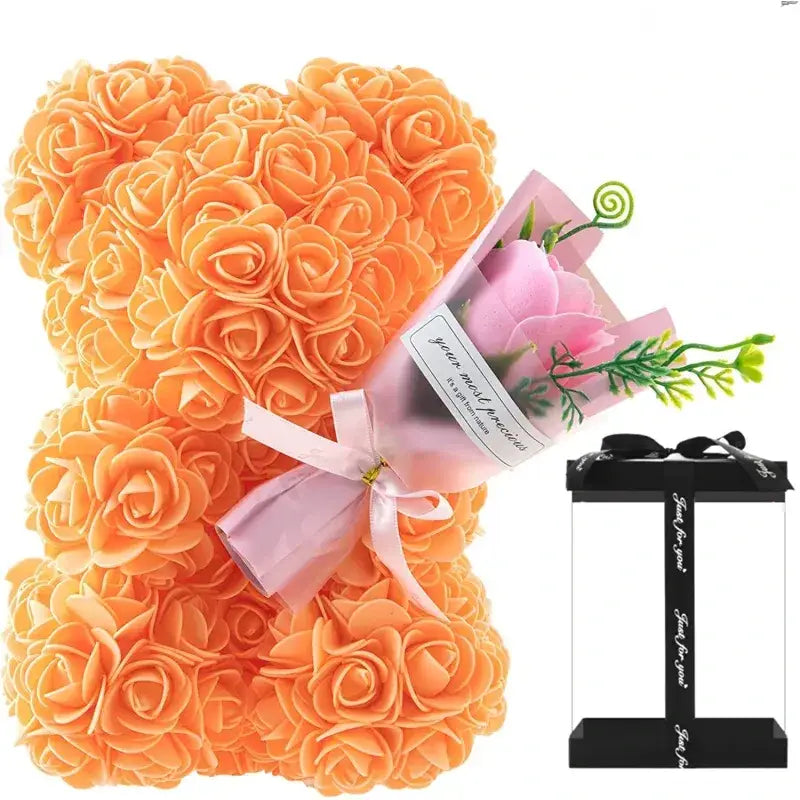 Orangish-orange rose-covered bear figurine with a pink ribbon bow.