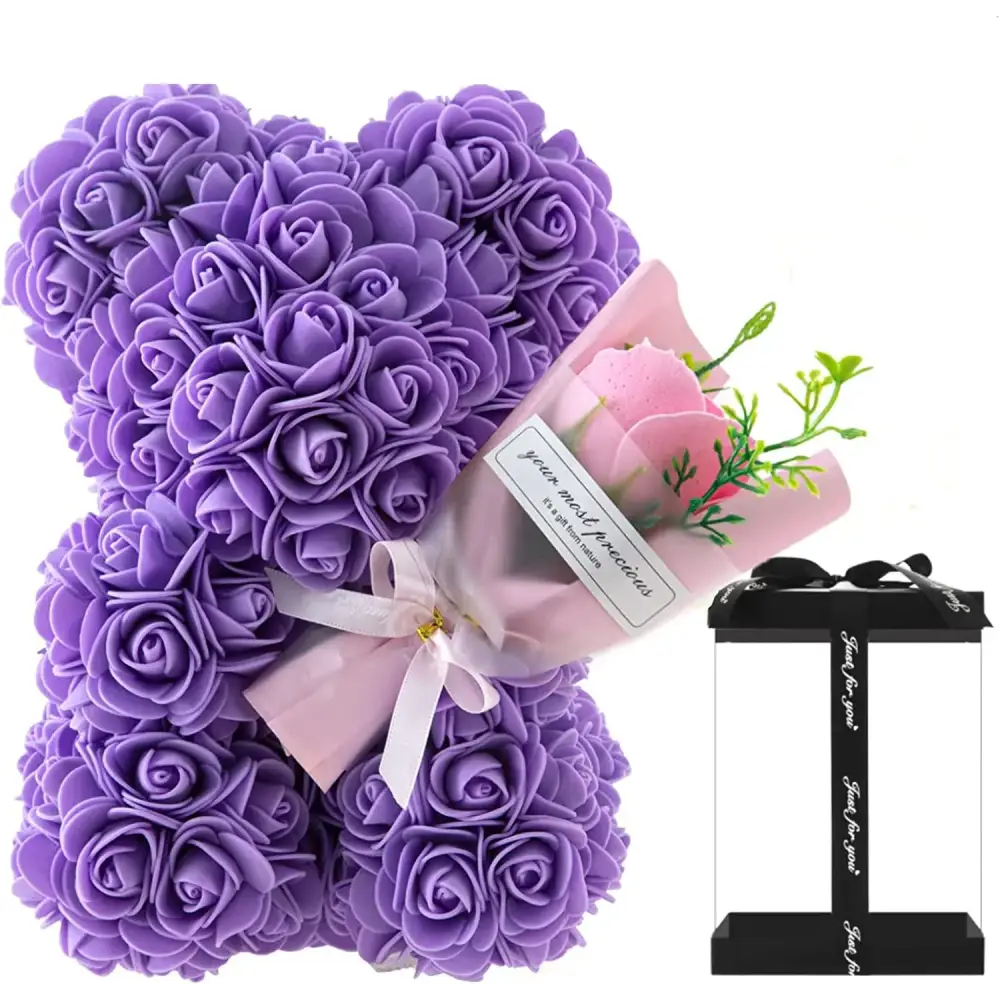 Purple rose-covered bear crafted from foam, wrapped with a pink ribbon and accompanied by a small bouquet of artificial flowers in a gift box.