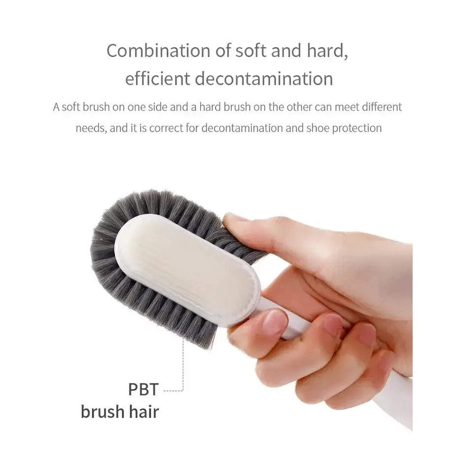 A dual-sided cleaning brush with a white handle and gray pbt bristles, designed for efficient decontamination.