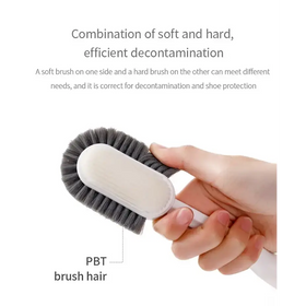 A dual-sided cleaning brush with a white handle and gray pbt bristles, designed for efficient decontamination.