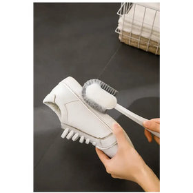 White shoe cleaning brush with soft bristles and a sleek handle.
