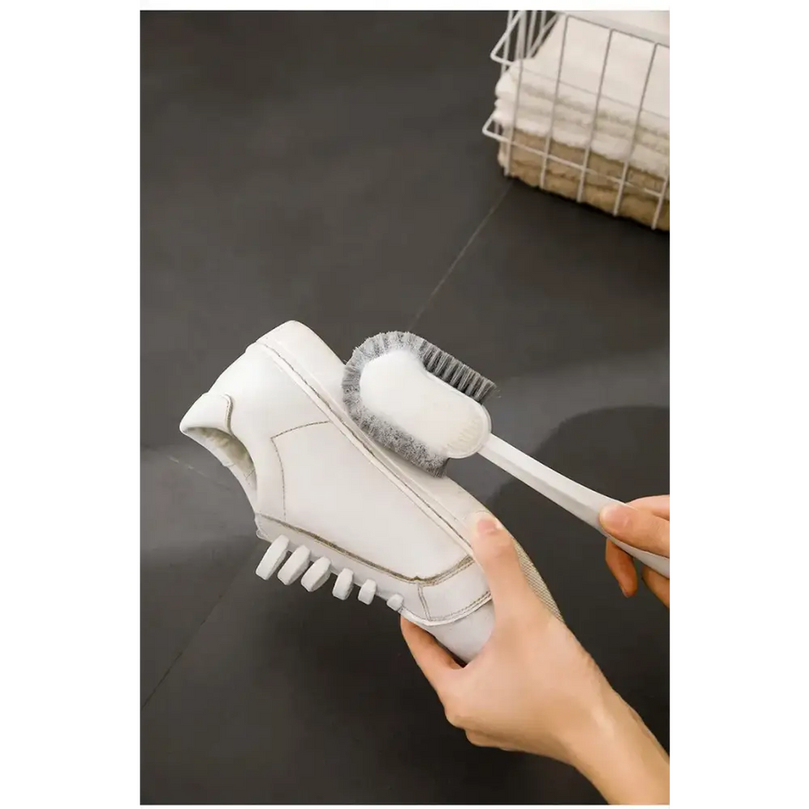 White shoe cleaning brush with soft bristles and a sleek handle.
