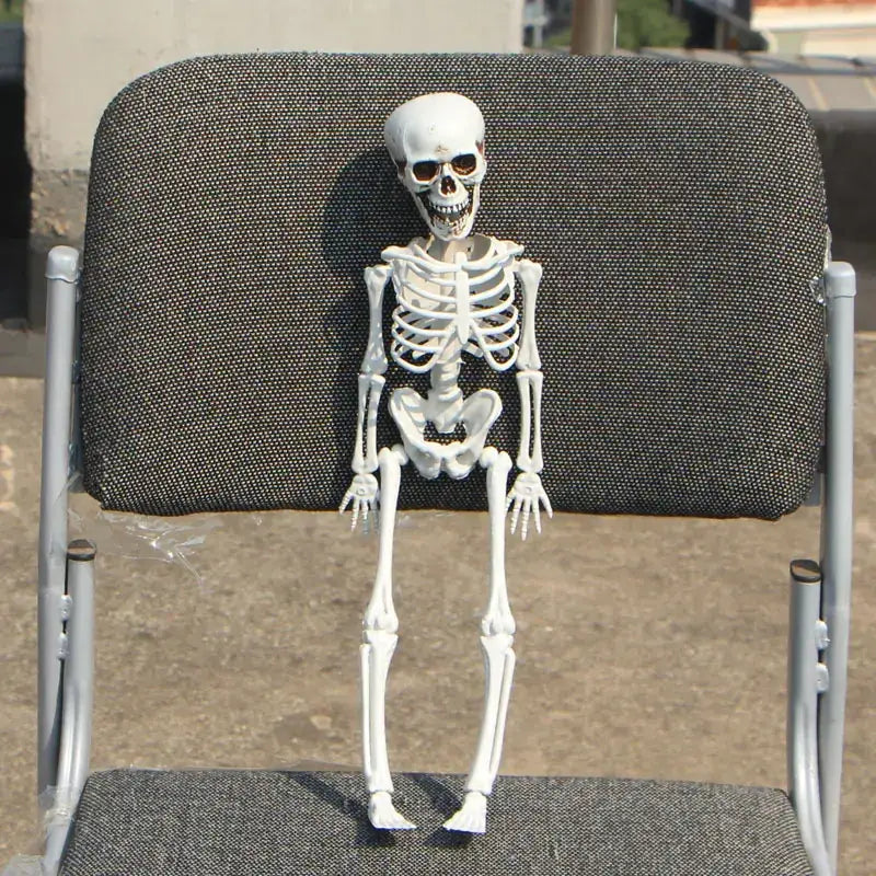 White plastic skeleton figurine with detailed bone structure and dark sunglasses.