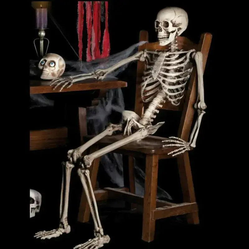 A detailed, off-white plastic skeleton figurine seated in a wooden chair with its arms resting on the table.