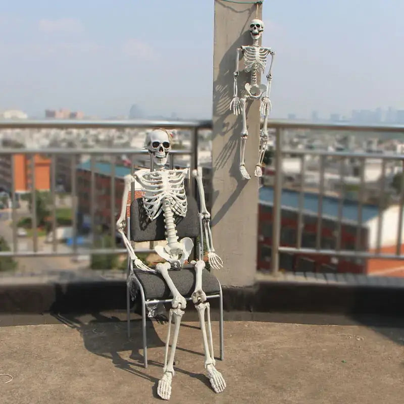 White plastic skeleton figurine seated in a chair.