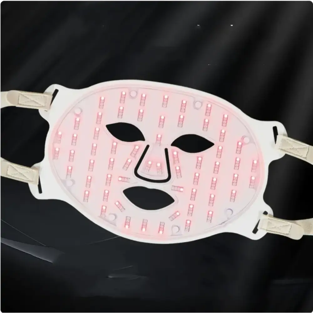 White led facial mask with pink glowing lights and black cutout features for eyes, nose, and mouth.