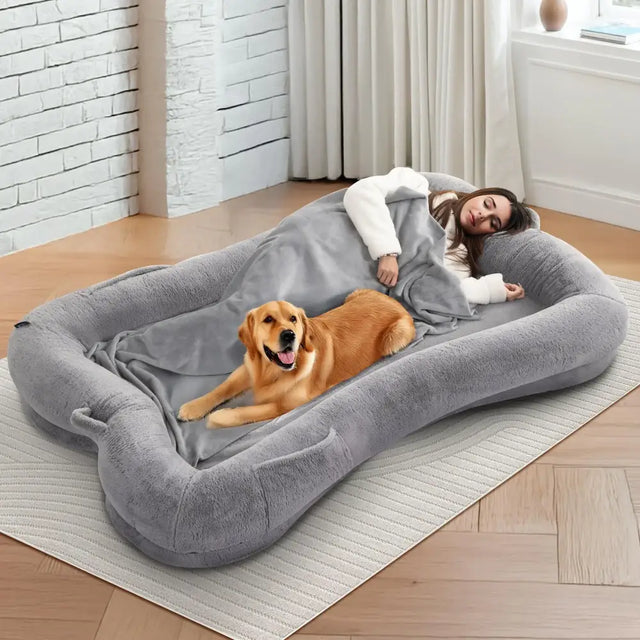 Gray plush rectangular dog bed with soft cushioned edges and a matching blanket