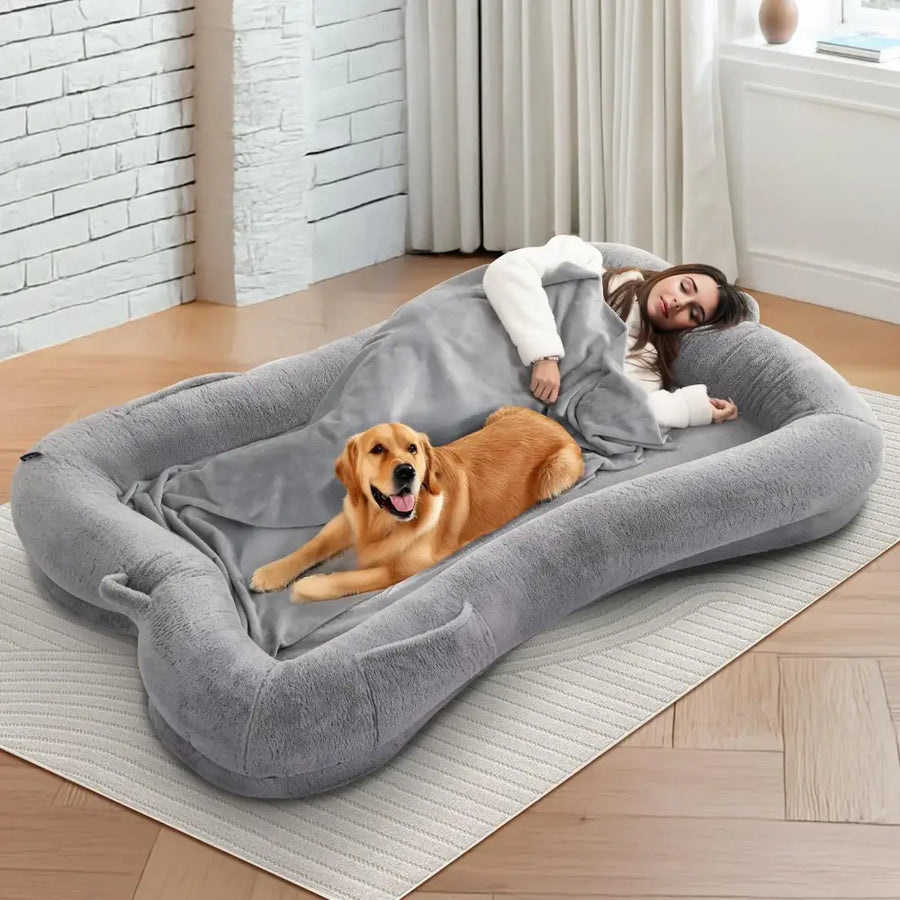 Gray plush rectangular dog bed with soft cushioned edges and a matching blanket