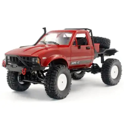 Red remote-controlled off-road truck with black tires and white rims, featuring a rugged front bumper and spare tire mounted on the side.
