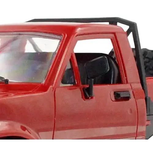 Red plastic model of a pickup truck with black roll bar and interior details.