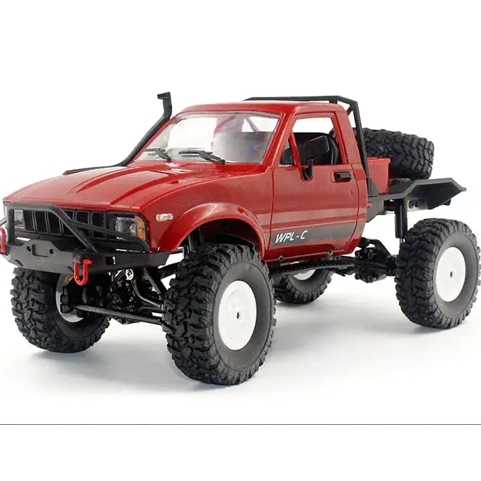 Red rc off-road pickup truck with black chassis and white-rimmed tires.