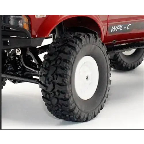 Red rc truck with black off-road tires and white rims.