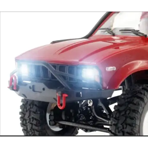 Red rc truck with black front bumper and bright white headlights.