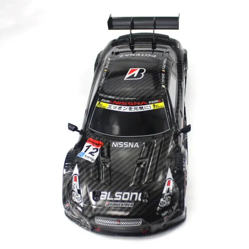 Black carbon fiber finish rc race car with sponsor decals and a rear spoiler.