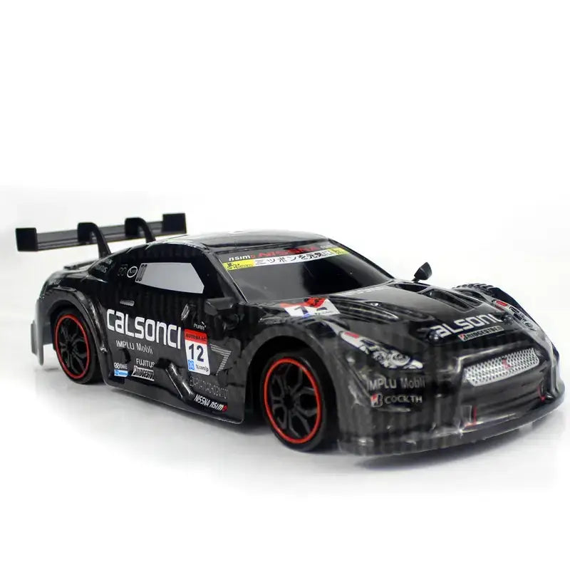 Black diecast race car model with red-accented wheels and detailed sponsor decals.