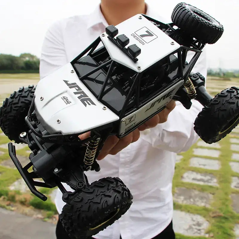 Black and white remote-controlled off-road buggy with rugged tires and a detailed chassis.