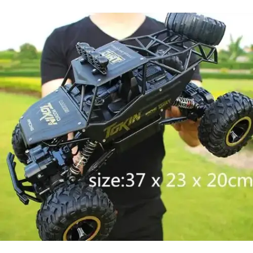 Black and gold remote-controlled off-road truck with rugged tires, detailed suspension system, and a visible ’tokin’ logo on the side.