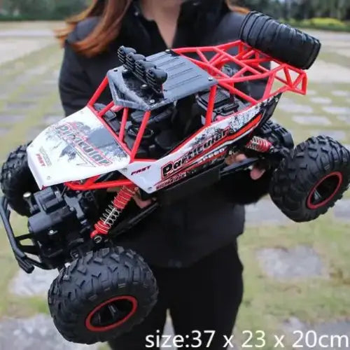 Red and black remote-controlled off-road truck with rugged tires and detailed suspension.