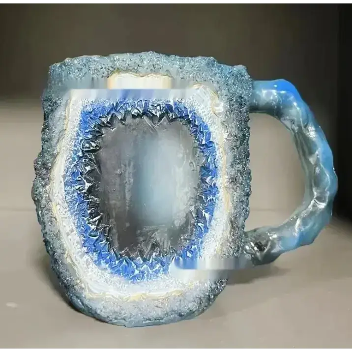 Blue and white geode-themed ceramic mug with a textured, crystalline exterior.
