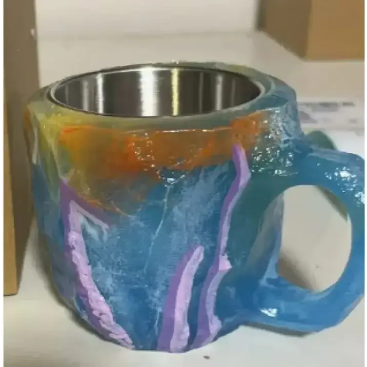 A vibrant, hand-painted ceramic mug with a stainless steel interior and bold blue, purple, orange, and teal swirls.