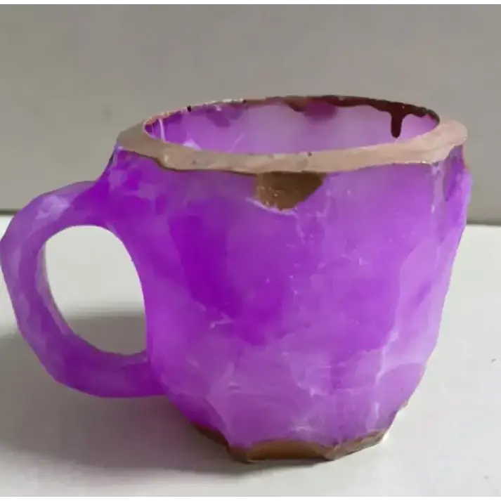 A purple, faceted mug with a chipped rim and base.