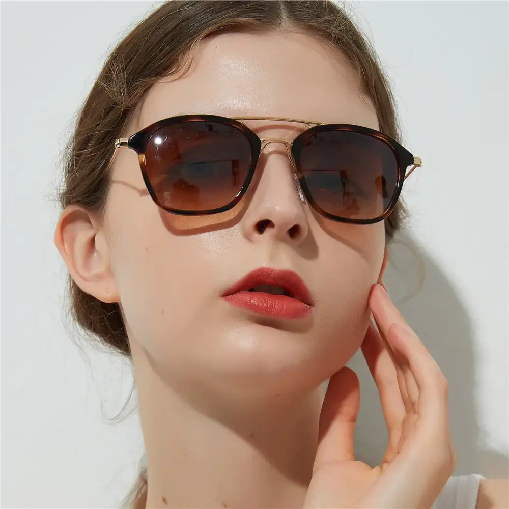 Tortoiseshell-framed sunglasses with gold-tone metal detailing and gradient brown lenses.