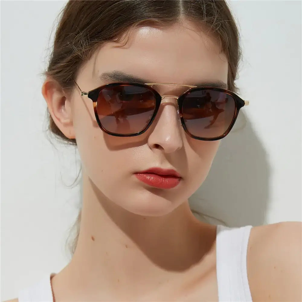 Tortoiseshell-framed sunglasses with gold-tone metal accents and gradient brown lenses.