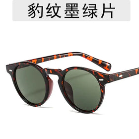 Tortoiseshell-patterned sunglasses with round frames and green-tinted lenses.
