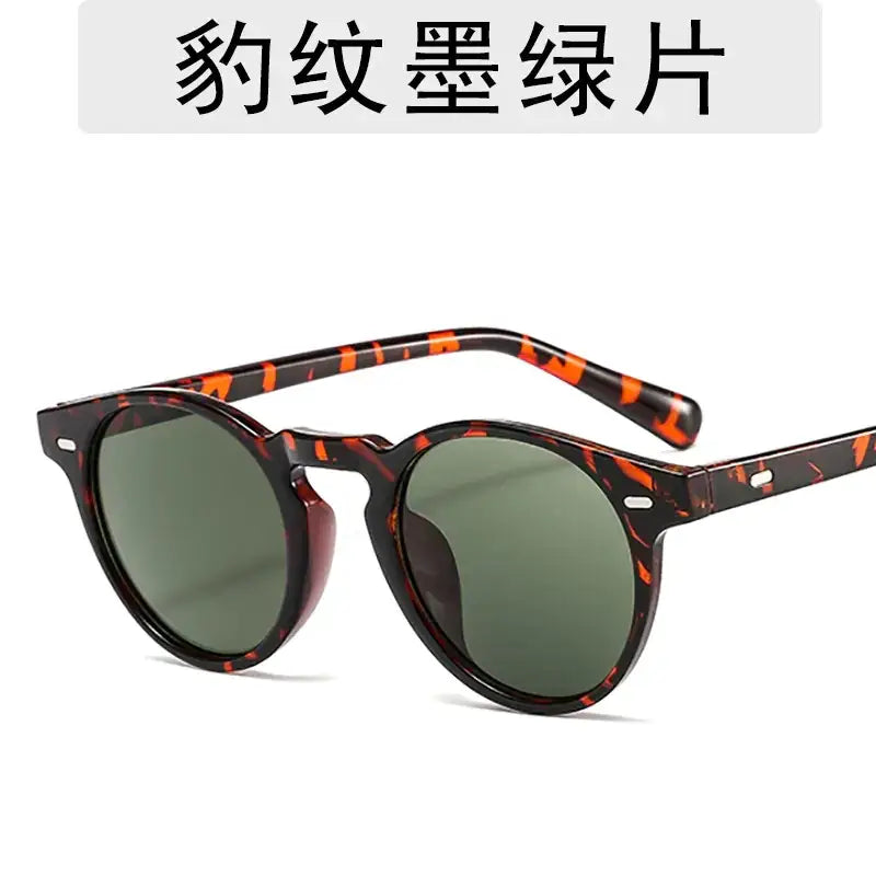 Tortoiseshell-patterned sunglasses with round frames and green-tinted lenses.