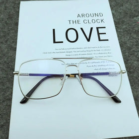 Silver-framed rectangular glasses with purple and black temple arms, featuring a gold-colored hinge.