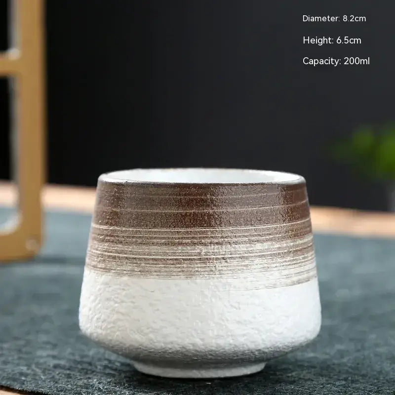A ceramic tea cup with a textured white base and brown upper section featuring horizontal ridges, measuring 8.2cm in diameter and holding 200ml.