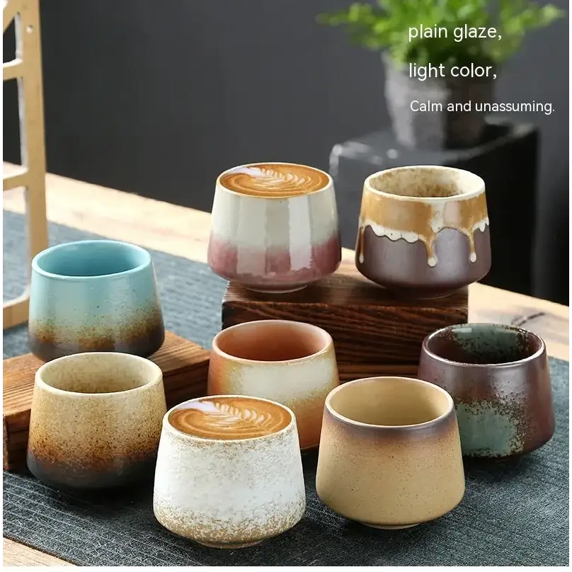 A collection of handcrafted ceramic tea cups with a plain glaze finish, featuring soft gradient colors like muted blues, earthy browns, and creamy whites.