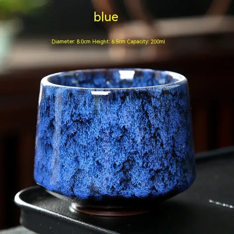 A vibrant blue ceramic teacup with a textured, speckled glaze and slightly flared rim.