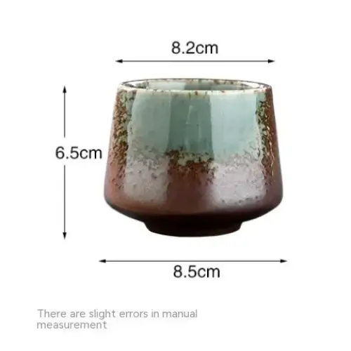 A ceramic teacup with a rustic, glazed finish featuring a gradient from deep brown at the base to light teal near the rim.