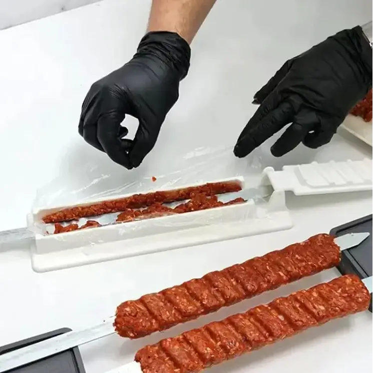 White plastic skewer meat filler tool with red ground meat inside