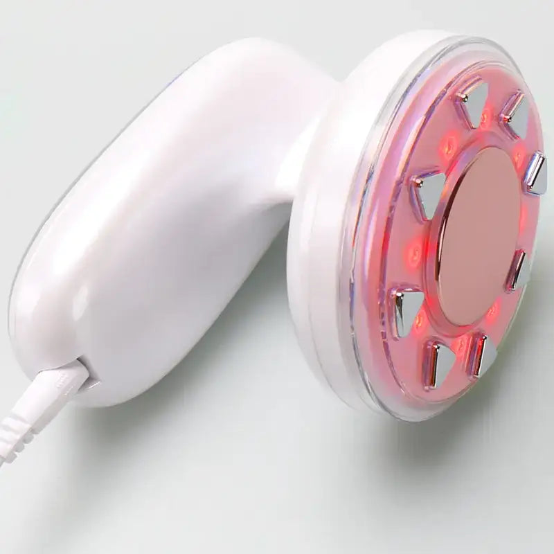 White handheld facial treatment device with a circular red led light panel and metallic accents.