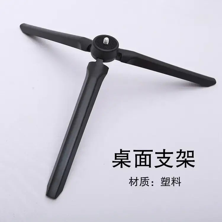 Black plastic tripod table stand with three adjustable legs and a central mounting plate.