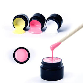 Pink gel nail polish in a black jar with a wooden applicator.