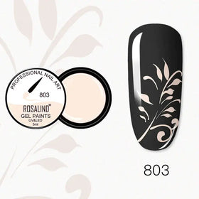 Rosalind 803 gel nail paint in a sleek black container with a creamy beige interior, showcasing its use on a glossy black nail adorned with delicate white leaf patterns.