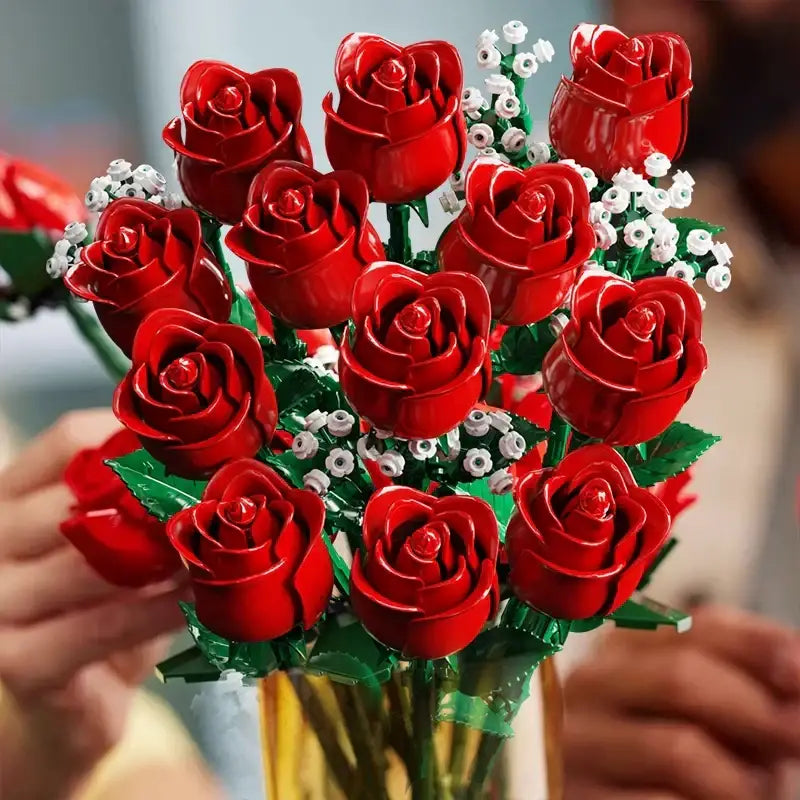 A vibrant red lego rose bouquet with green stems and delicate white filler flowers, assembled from plastic bricks.