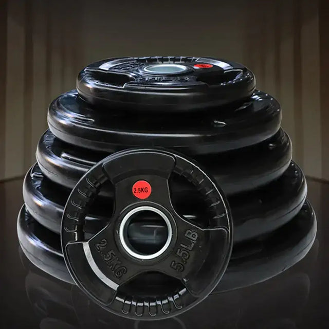 Black rubber-coated weight plates, each marked with a red 2.5kg label and silver ’2.5lb’ text on the rim.