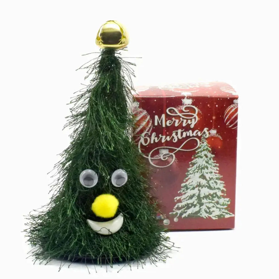 A cheerful green christmas tree figurine with googly eyes, a yellow pom-pom nose, and a smiling mouth.
