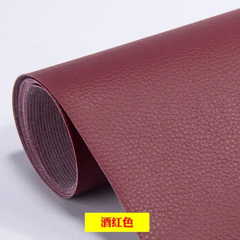 A rolled-up sheet of wine-red faux leather with a textured, pebbled surface.