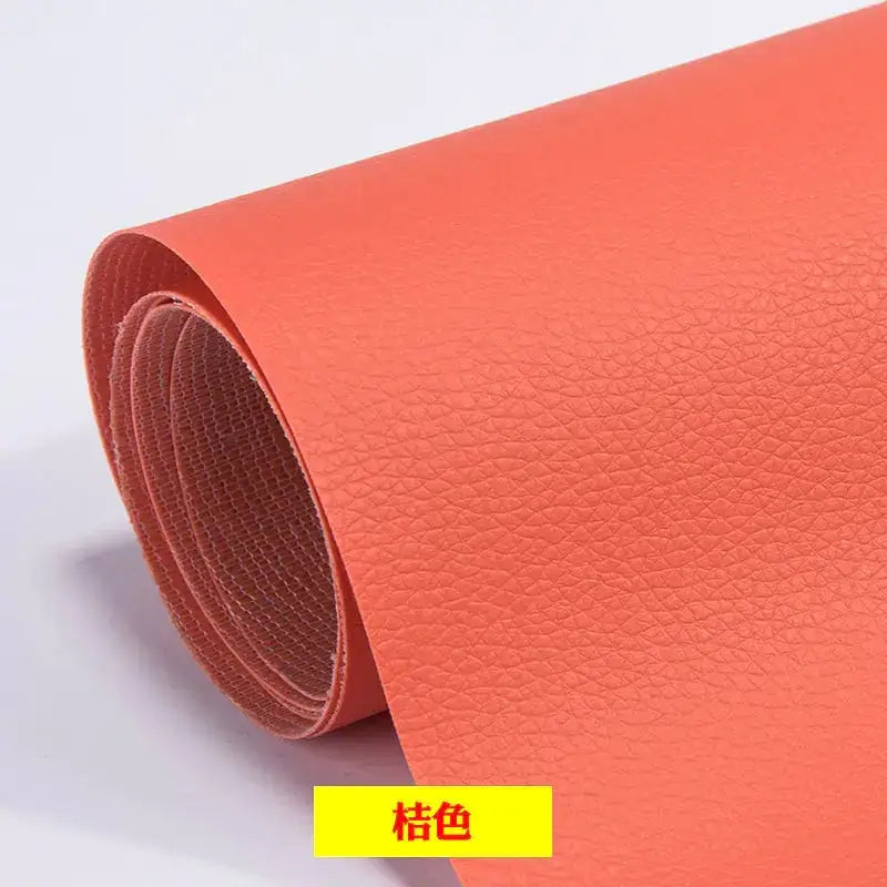 A roll of vibrant coral-colored faux leather with a textured, pebbled surface.